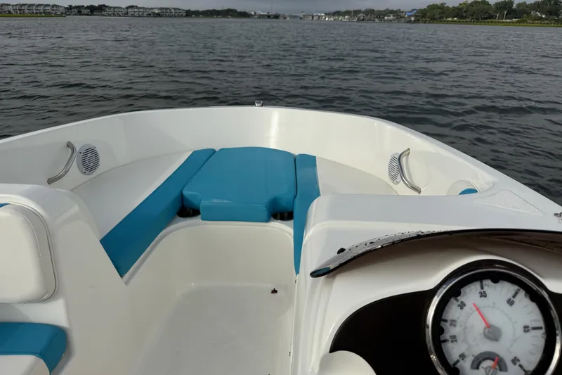 Slide: The Image of 2022 Bayliner Element E18 boat interior with blue seating on a calm lake. - 25