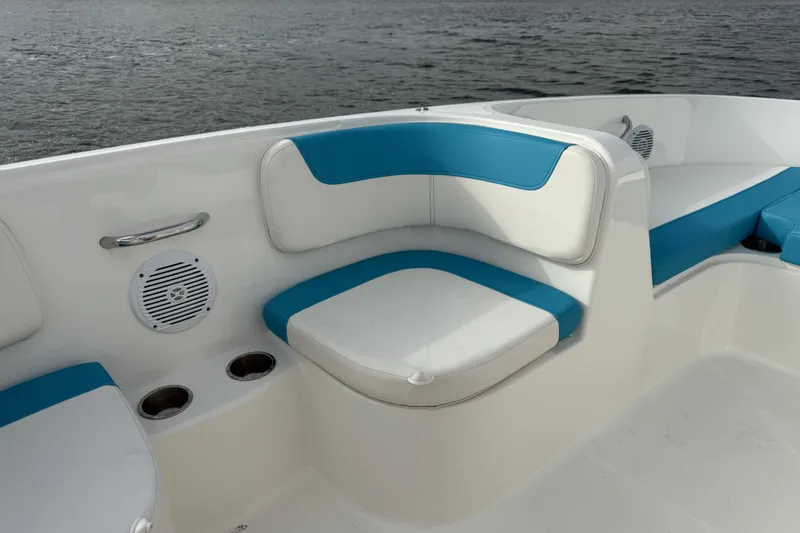 Slide: The Image of 2022 Bayliner Element E18 boat interior with blue and white seating, cup holders, and speaker. - 26