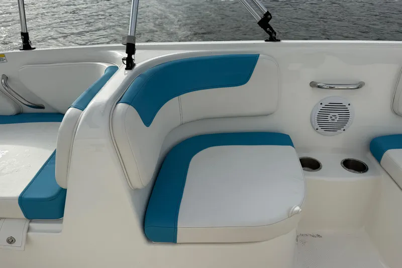 Slide: The Image of 2022 Bayliner Element E18 boat interior with blue and white seating, cup holders, and speaker. - 29