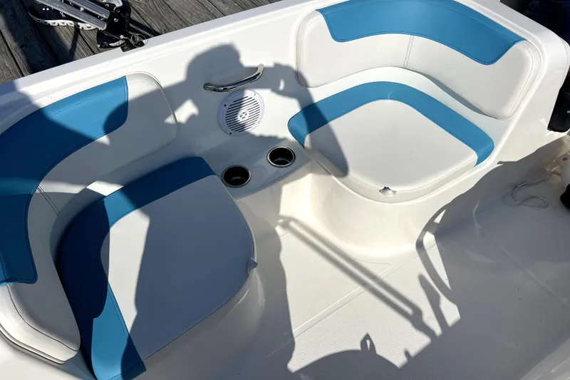 Slide: The Image of 2022 Bayliner Element E18 boat interior with blue and white seating and cup holders. - 33