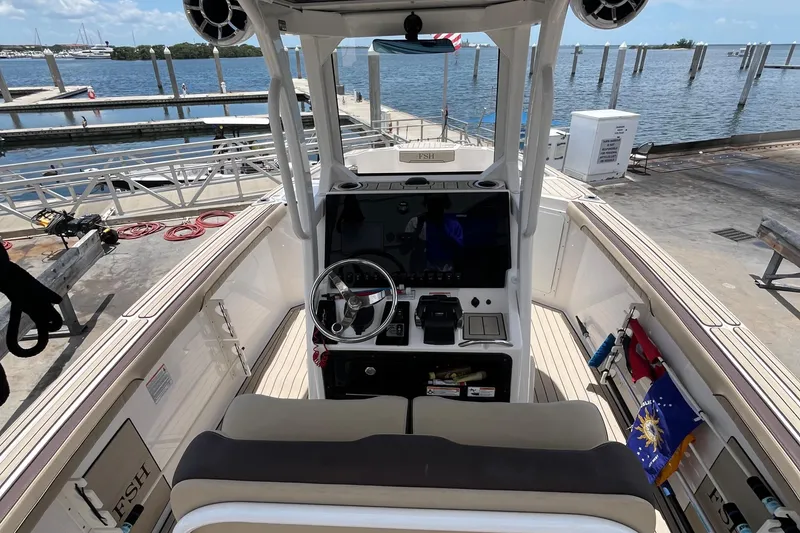 Slide: The Image of 2022 Yamaha Boats 252 FSH Sport at dock, showcasing helm and seating area. - 11