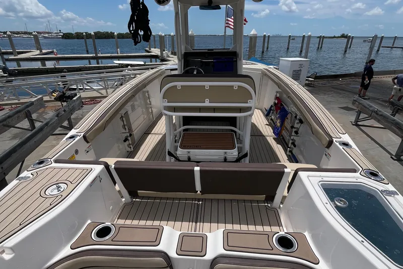 Slide: The Image of 2022 Yamaha Boats 252 FSH Sport at dock, showcasing spacious deck and seating. - 5