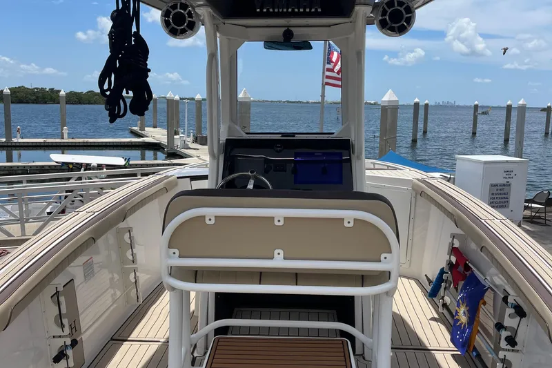 Slide: The Image of 2022 Yamaha Boats 252 FSH Sport at dock, featuring helm and seating area. - 8