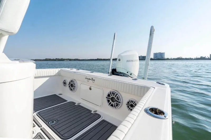 Slide: The Image of 2021 Canyon Bay 24H boat on water, featuring Mercury engine and sleek deck design. - 10