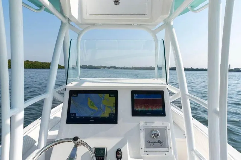 Slide: The Image of 2021 Canyon Bay 24H boat dashboard with navigation screens on open water. - 8
