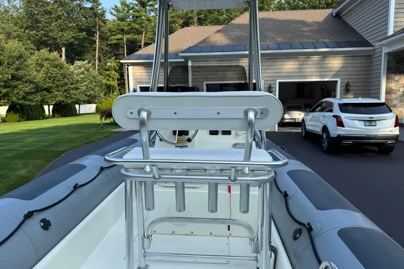 Slide: The Image of 2010 Zodiac Pro Open 650 boat parked in a driveway with a house and cars. - 10