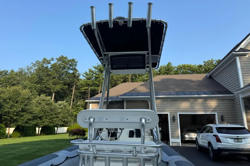 Slide: The Image of 2010 Zodiac Pro Open 650 boat with T-top, parked near a house and garage. - 11