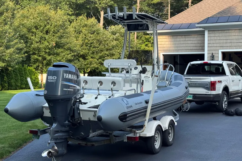 Slide: The Image of 2010 Zodiac Pro Open 650 boat on trailer, parked in driveway with truck nearby. - 14
