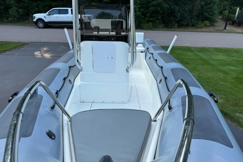 Slide: The Image of 2010 Zodiac Pro Open 650 boat with gray seating, parked on grass. - 6