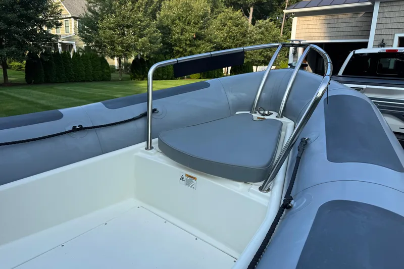 Slide: The Image of 2010 Zodiac Pro Open 650 boat with gray seating and railing, parked in a residential area. - 7