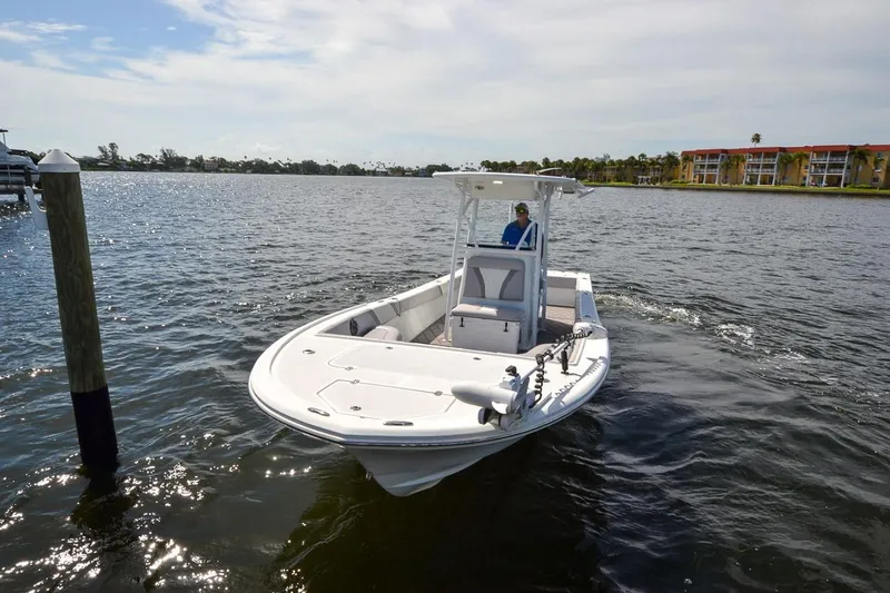 Slide: The Image of 2020 Canyon Bay 28h boat cruising on a sunny day near waterfront buildings. - 10
