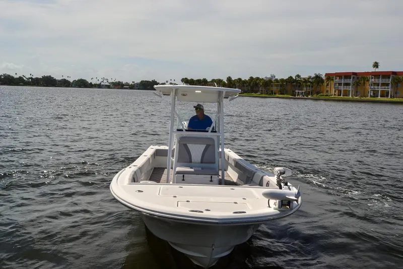 Slide: The Image of 2020 Canyon Bay 28h boat cruising on a calm waterway near waterfront buildings. - 11