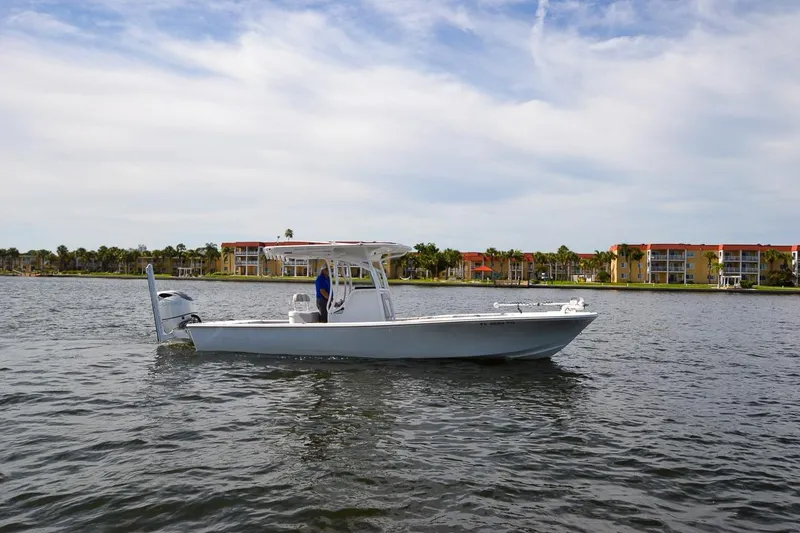 Slide: The Image of 2020 Canyon Bay 28h boat on water with coastal buildings in background. - 12