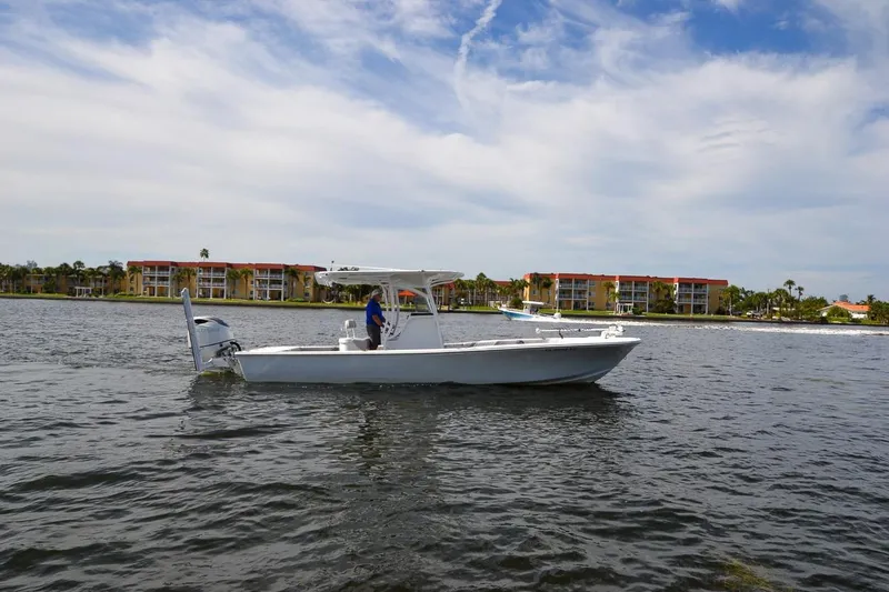 Slide: The Image of 2020 Canyon Bay 28h boat on water with buildings in background. - 13