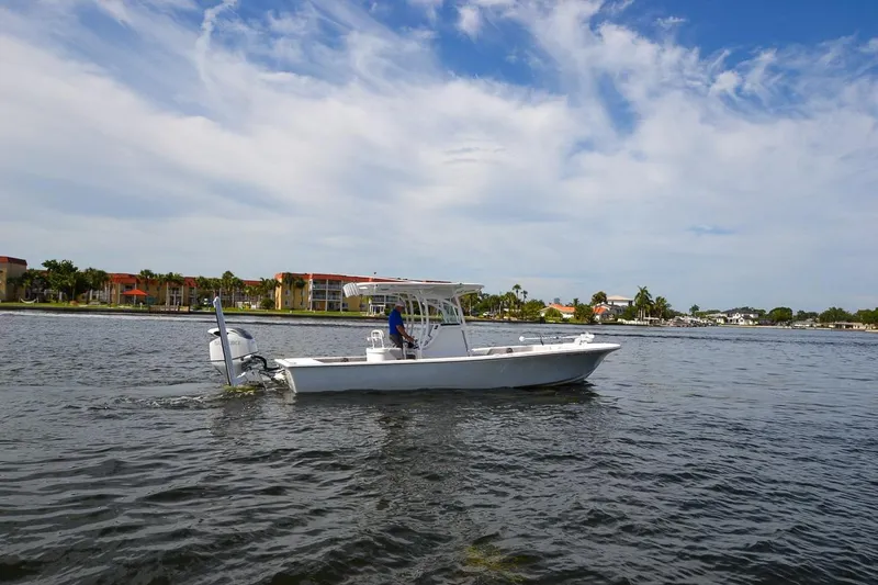 Slide: The Image of 2020 Canyon Bay 28h boat cruising on a calm waterway under a partly cloudy sky. - 14