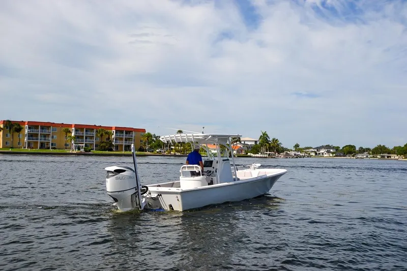 Slide: The Image of 2020 Canyon Bay 28h boat cruising on a scenic waterway with buildings in the background. - 15