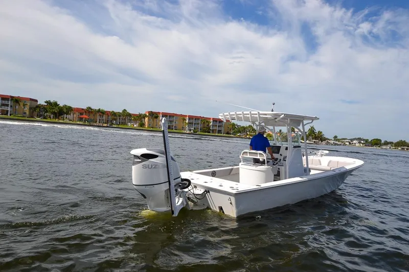 Slide: The Image of 2020 Canyon Bay 28h boat cruising on a scenic waterway with buildings in the background. - 17