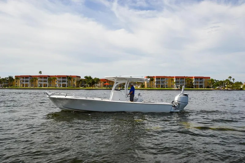 Slide: The Image of 2020 Canyon Bay 28h boat on water with buildings in background. - 20