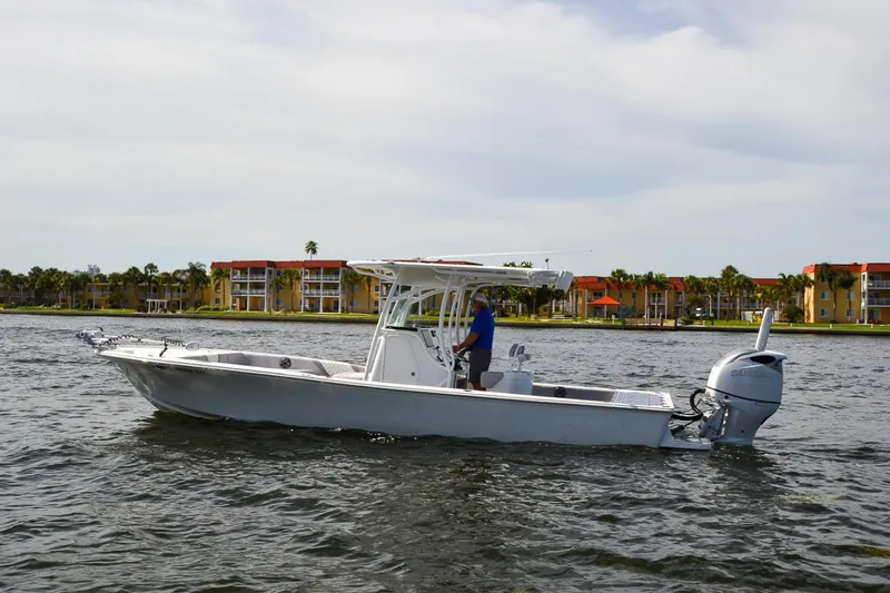 Slide: The Image of 2020 Canyon Bay 28h boat cruising on a calm waterway near colorful waterfront buildings. - 22