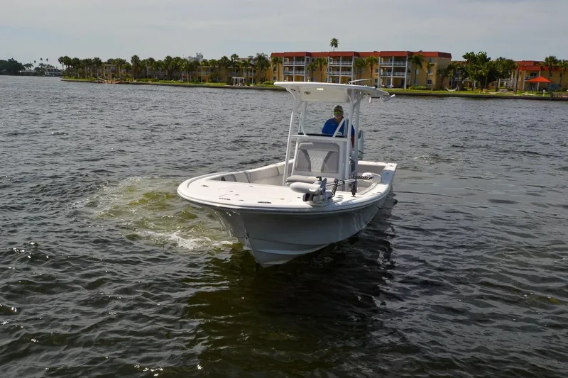 Slide: The Image of 2020 Canyon Bay 28h boat cruising on a scenic waterfront with buildings in the background. - 25