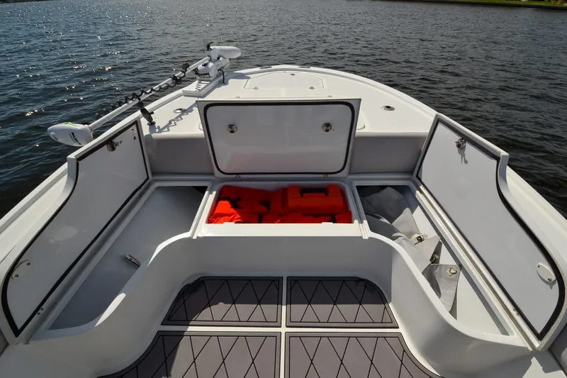 Slide: The Image of 2020 Canyon Bay 28h boat with open storage compartments on calm water. - 29