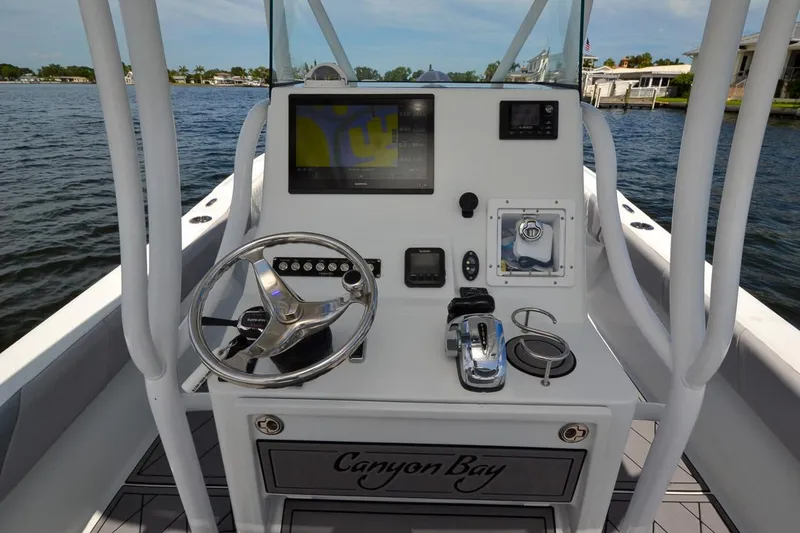 Slide: The Image of Cockpit of 2020 Canyon Bay 28h boat with steering wheel and navigation controls. - 34