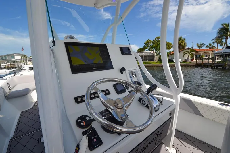 Slide: The Image of 2020 Canyon Bay 28h boat dashboard with steering wheel and navigation display. - 38