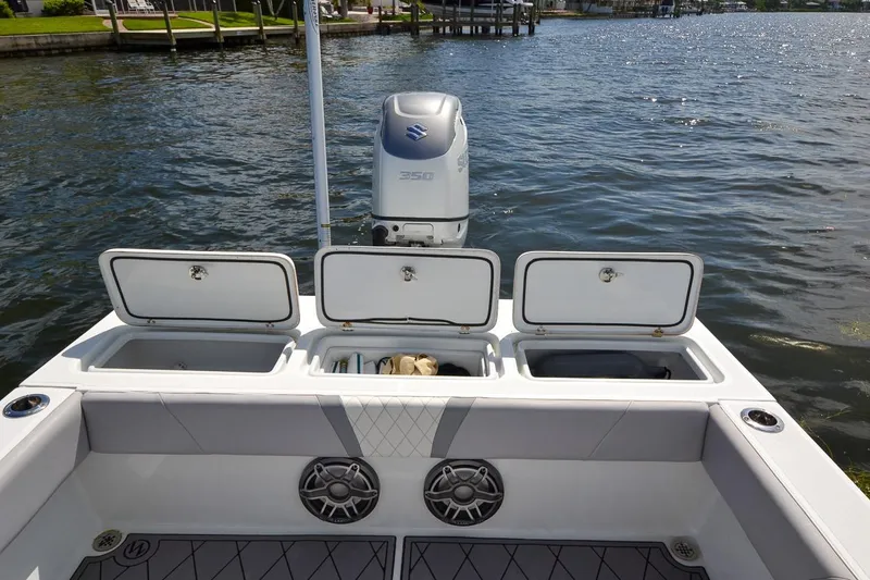 Slide: The Image of 2020 Canyon Bay 28h boat with open storage compartments and Suzuki outboard motor. - 42