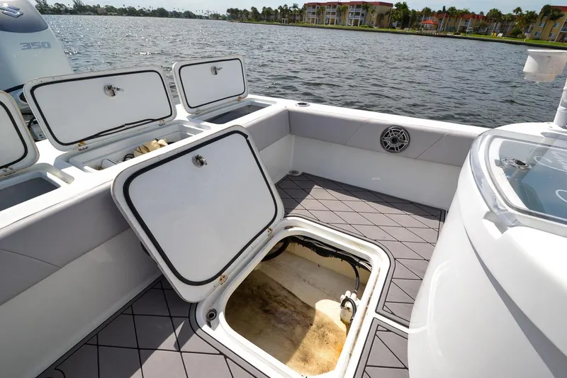 Slide: The Image of 2020 Canyon Bay 28h boat interior with open storage compartments by the water. - 45