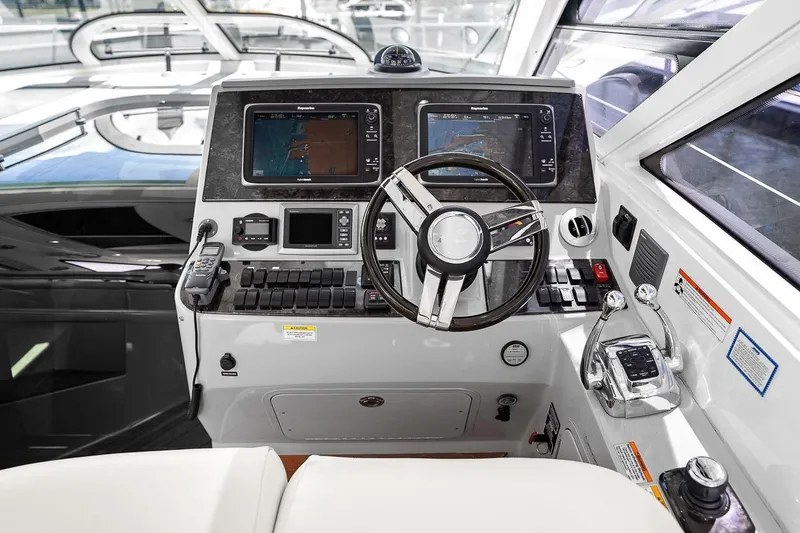 Slide: The Image of Helm of 2012 Sea Ray 470 Sundancer with dual navigation screens and modern controls. - 1