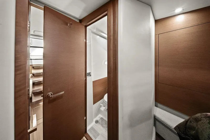 Slide: The Image of Interior of 2012 Sea Ray 470 Sundancer yacht, featuring modern wood finishes and compact bathroom. - 24