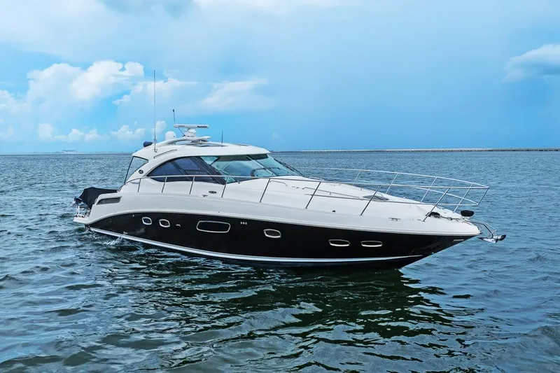 Slide: The Image of 2012 Sea Ray 470 Sundancer yacht cruising on open water under a clear blue sky. - 38