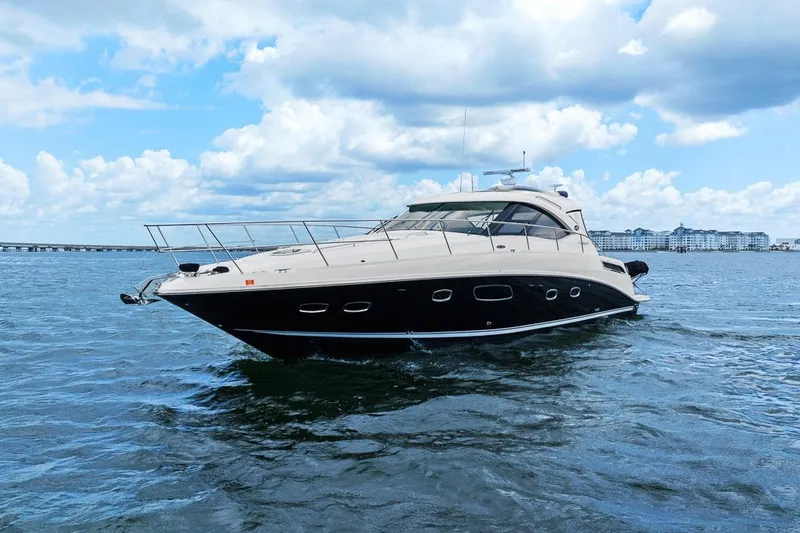Slide: The Image of 2012 Sea Ray 470 Sundancer yacht cruising on open water under a cloudy sky. - 44