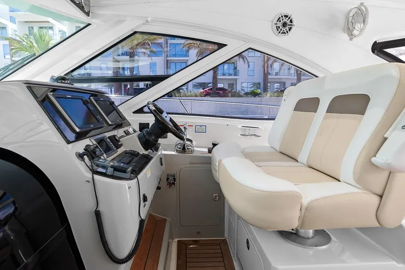 Slide: The Image of 2012 Sea Ray 470 Sundancer helm with dual seats and advanced navigation controls. - 59