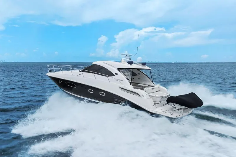 Slide: The Image of 2012 Sea Ray 470 Sundancer yacht cruising on open water under a clear blue sky. - 63