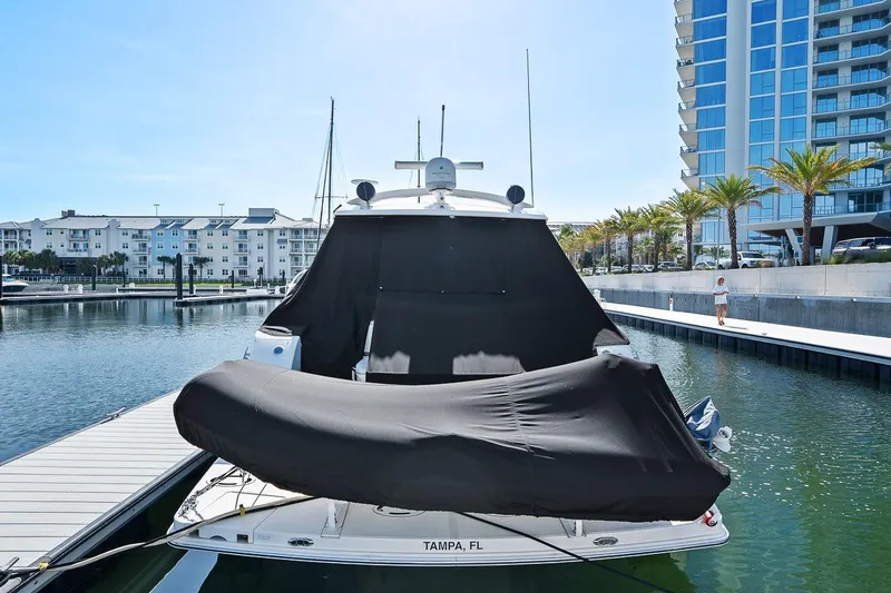 Slide: The Image of 2012 Sea Ray 470 Sundancer yacht docked in marina, covered, with modern buildings in background. - 8