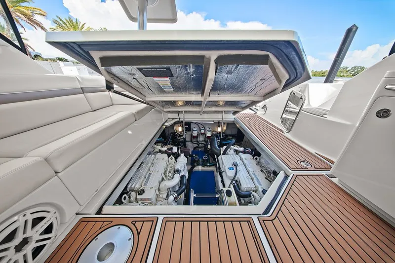 Slide: The Image of Engine compartment of 2012 Sea Ray 470 Sundancer yacht, showcasing twin engines and teak flooring. - 9