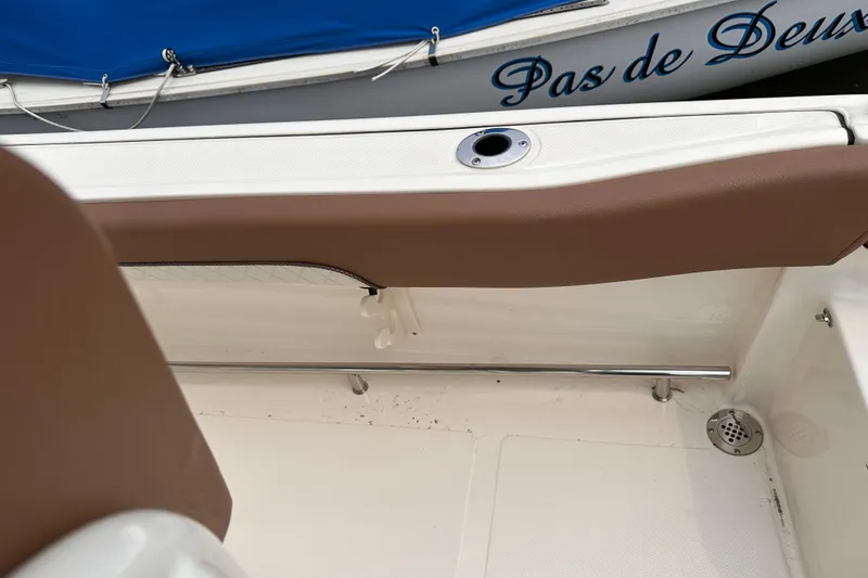 Slide: The Image of 2024 Pioneer 222 Islander boat interior with brown seating and stainless steel railing. - 6