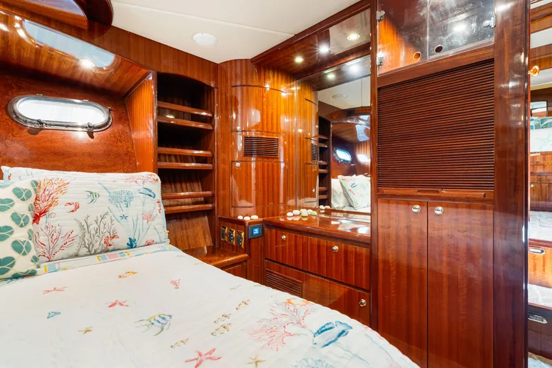 Slide: The Image of Luxurious 2007 Hampton 558 Pilothouse yacht cabin with elegant wood finish and nautical-themed bedding. - 34