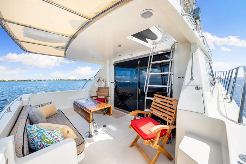 Slide: The Image of Luxurious 2007 Hampton 558 Pilothouse yacht deck with seating, table, and ocean view. - 53
