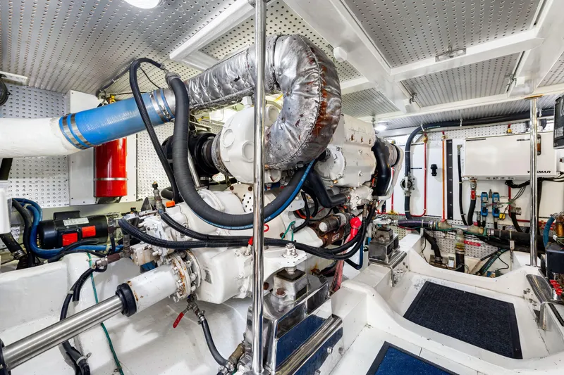 Slide: The Image of Engine room of 2007 Hampton 558 Pilothouse yacht, featuring complex machinery and piping. - 67