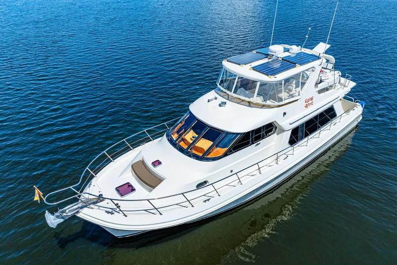 Slide: The Image of 2007 Hampton 558 Pilothouse yacht on calm blue water, showcasing sleek design and solar panels. - 72