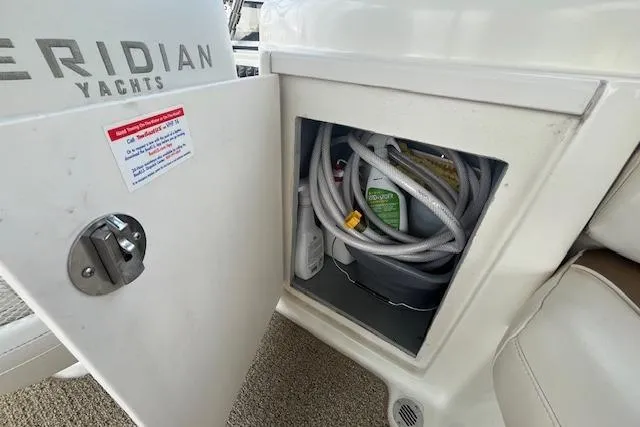 Slide: The Image of Open storage compartment on 2005 Meridian 368 Motoryacht with hoses and cleaning supplies. - 26