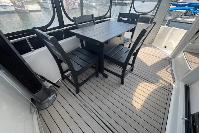 Slide: The Image of 2005 Meridian 368 Motoryacht deck with dining table and chairs, overlooking marina. - 30