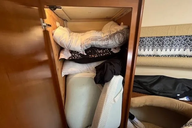Slide: The Image of Storage compartment in 2005 Meridian 368 Motoryacht filled with bedding and cushions. - 40