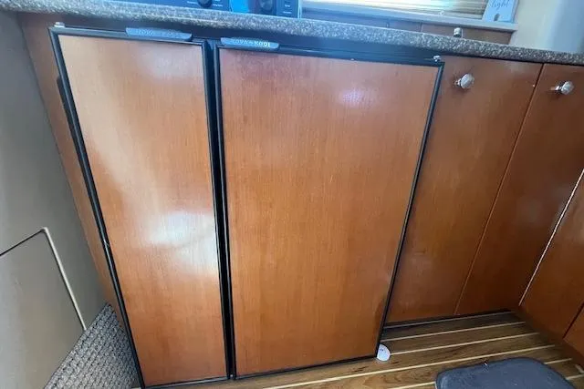 Slide: The Image of Wooden cabinetry in 2005 Meridian 368 Motoryacht kitchen, featuring dual-door fridge and countertop. - 44