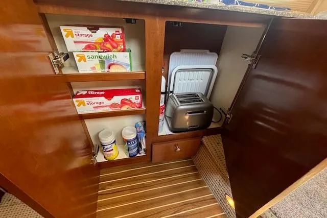 Slide: The Image of Cabinet interior of 2005 Meridian 368 Motoryacht with storage bags, toaster, and cleaning supplies. - 49