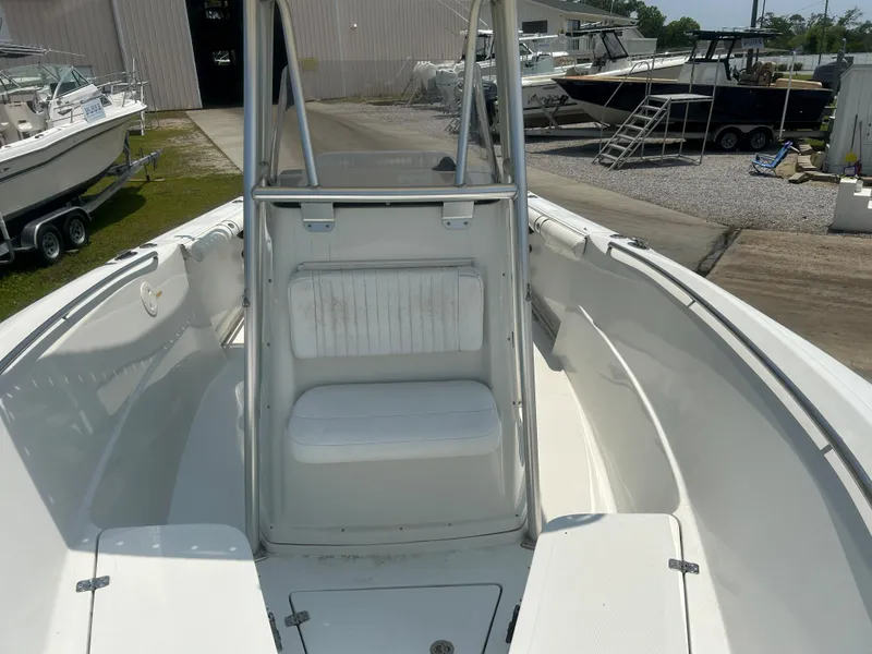 Slide: The Image of 2004 Sailfish 236 CC boat interior, featuring white seating and spacious deck area. - 13