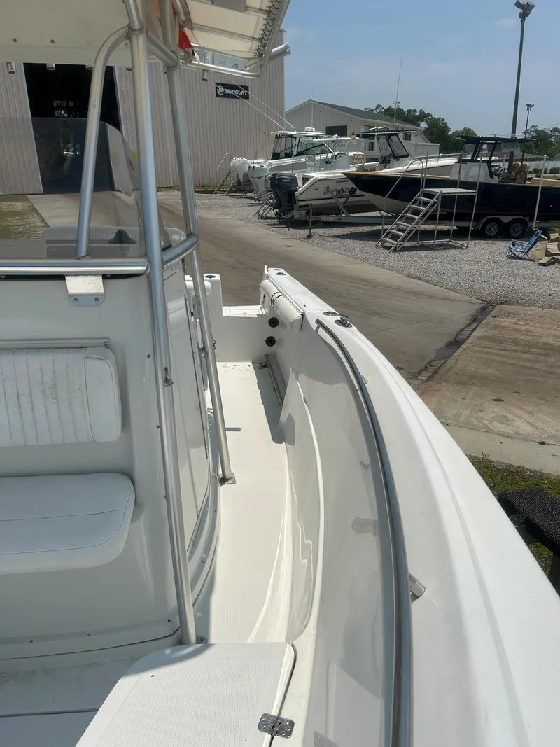 Slide: The Image of 2004 Sailfish 236 CC boat docked, showcasing sleek design and spacious deck area. - 15