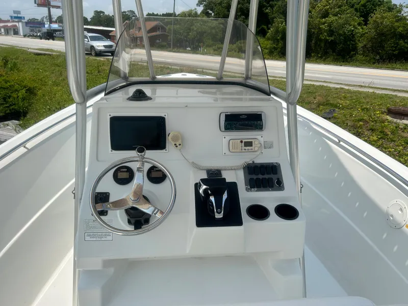 Slide: The Image of 2004 Sailfish 236 CC boat console with steering wheel, controls, and navigation equipment. - 18